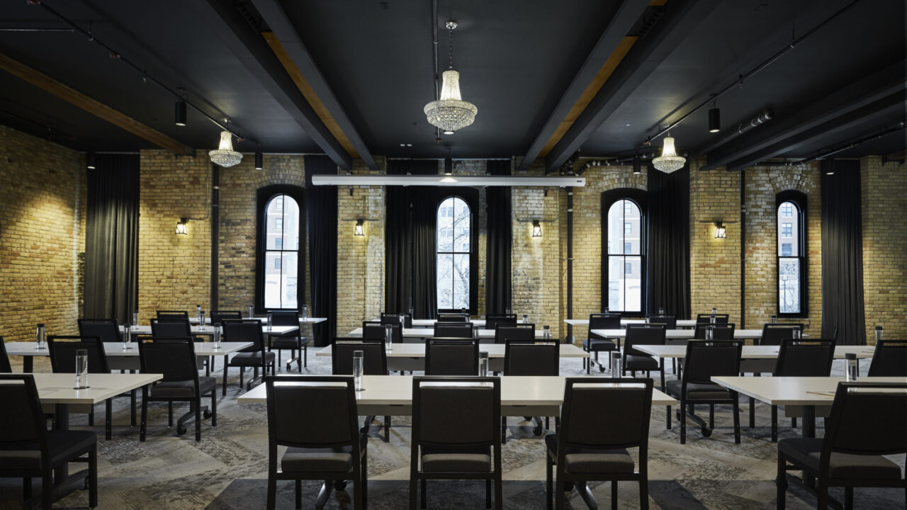Exposed brick ballroom with classroom-style seating at our hotel in Twin Cities