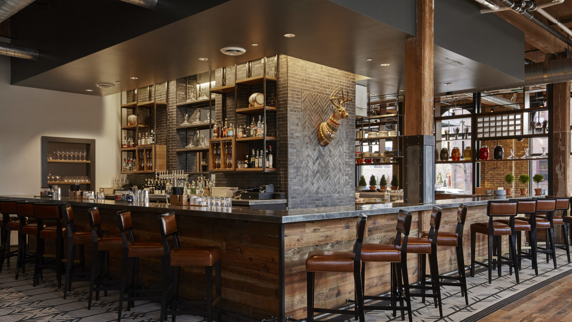 Cozy wooden bar with neatly lined up stools at our Minneapolis boutique hotel