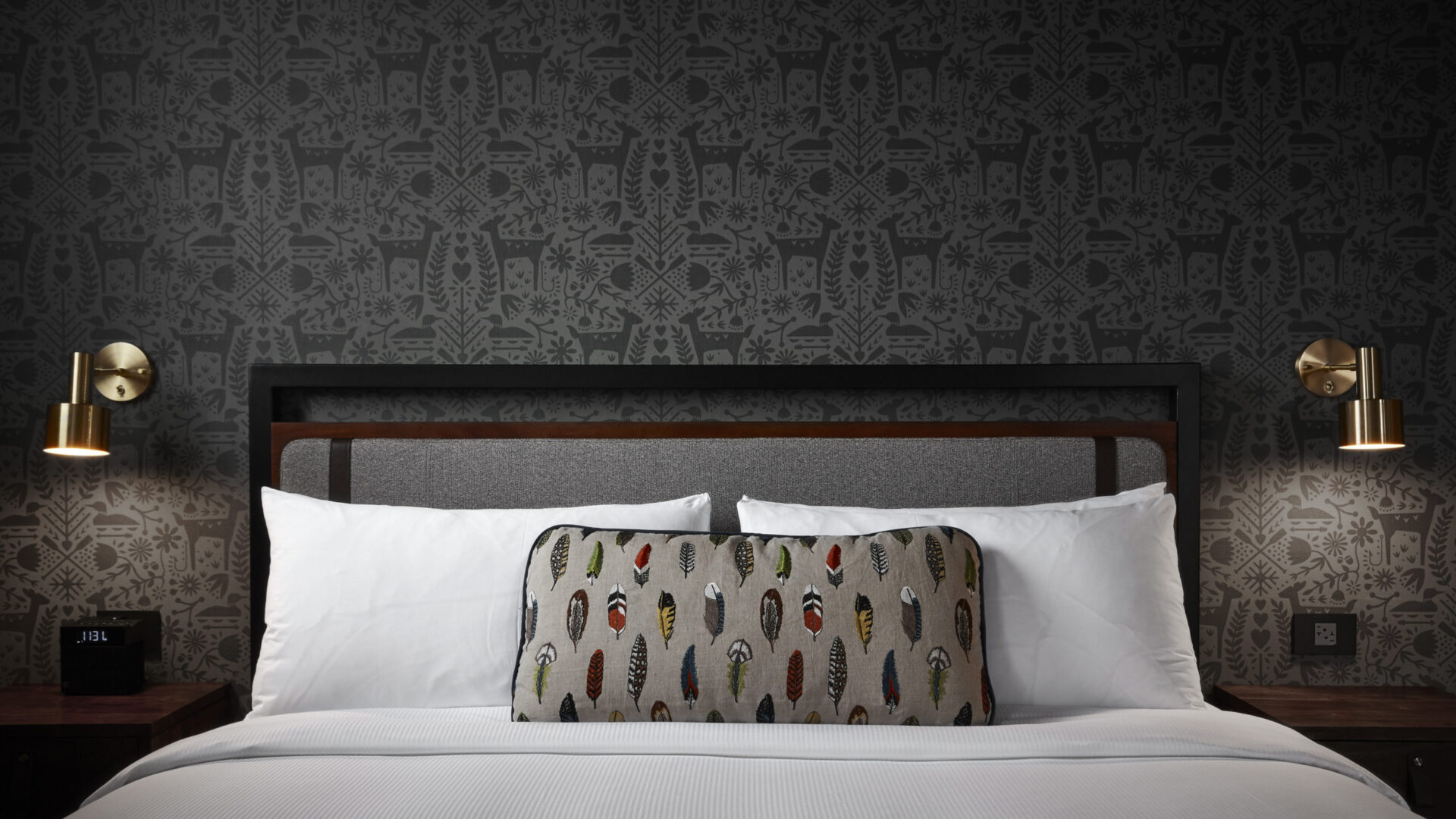 Wildlife-themed wallpaper over the head of a North Loop hotel bed