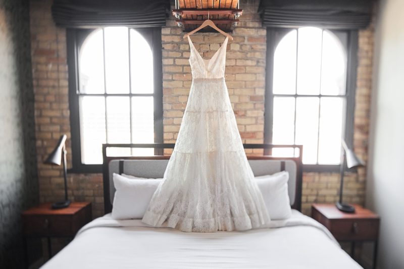 Wedding dress hanging above a bed at our North Loop hotel in Minneapolis