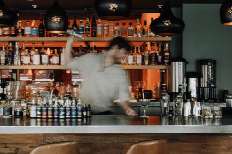 Motion-blurred bartender shaking a cocktail behind our downtown Minneapolis bar