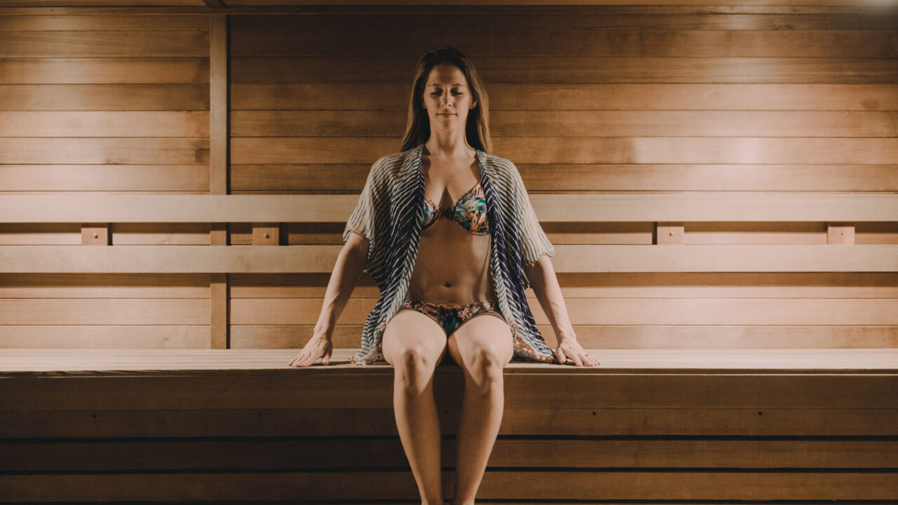 Woman in a swimsuit sitting in our Minneapolis hotel's sauna