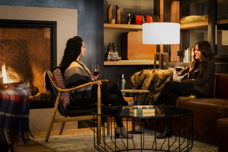 Two women chatting near the fire at our boutique hotel in Minneapolis