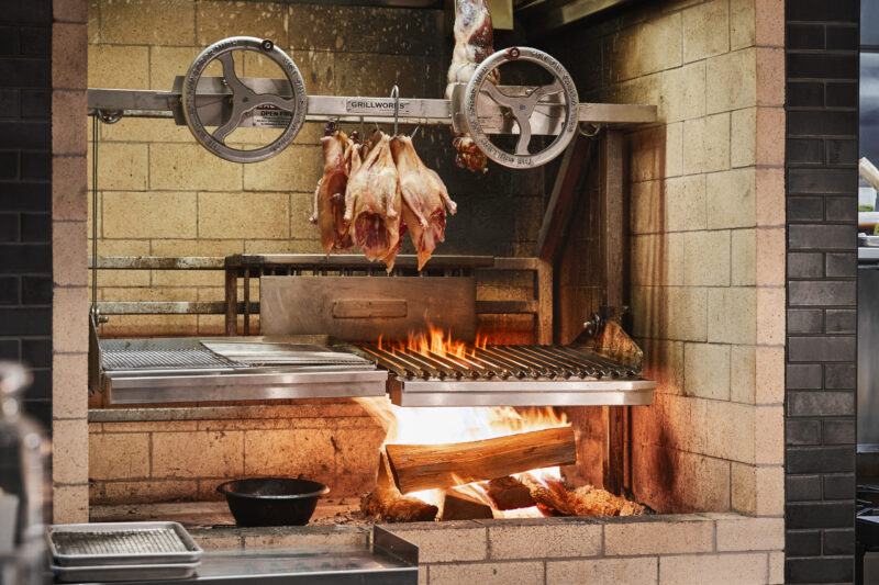 Whole chickens over a fire, waiting to be cooked at our Minneapolis boutique hotel