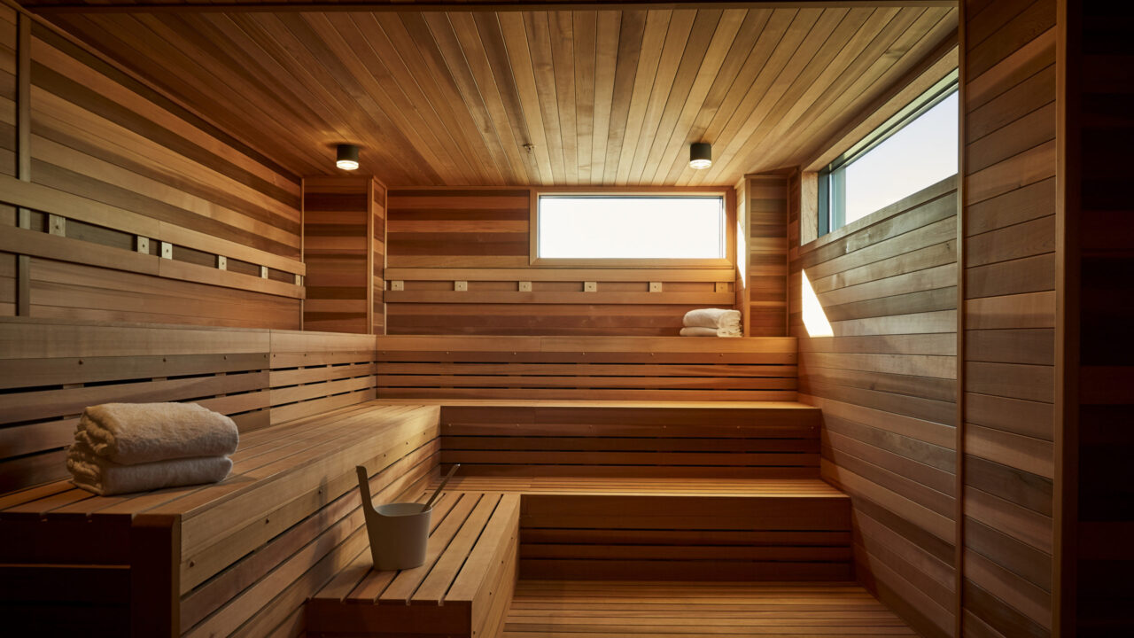 Wooden sauna with raised benches and small windows at our Minneapolis hotel