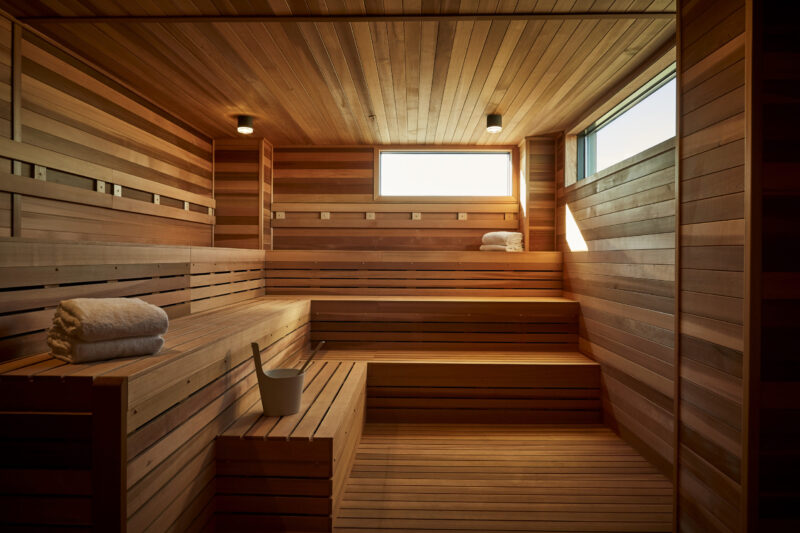 Wooden sauna with raised benches and small windows at our Minneapolis hotel