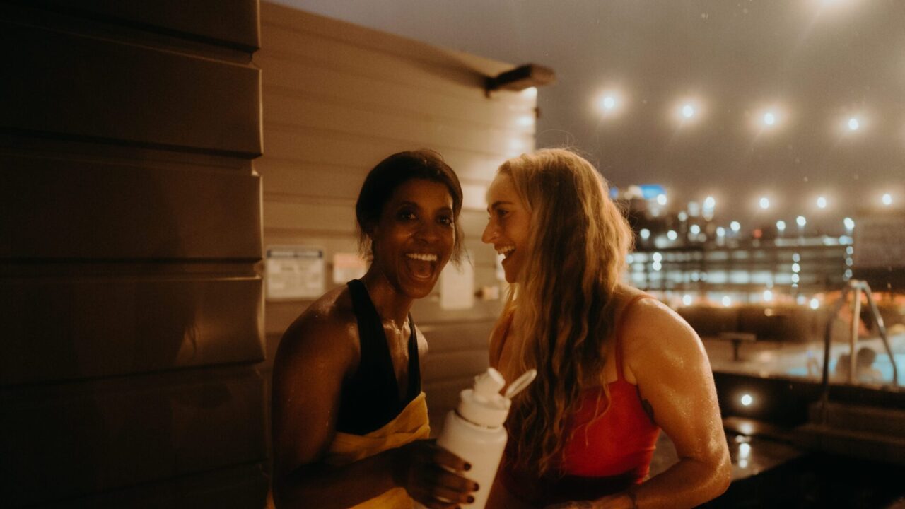 Two women smiling by our Minneapolis hotel's rooftop pool