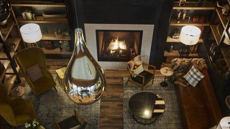 Birds-eye view of a den-like lobby area with a fire at Hewing Hotel in MPLS